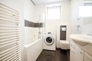 a white bathroom with a washing machine and a sink at Studio16 in Nowy Sącz