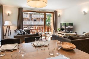 una sala de estar con una mesa con copas de vino. en K2 by Alpine Residences, en Les Gets