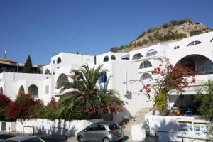 a white building with cars parked in front of it at Pissouri Beach Apartments in Pissouri
