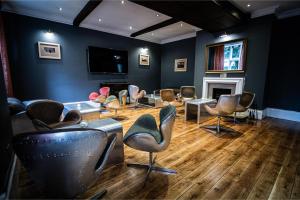 a waiting room with chairs and a tv and a fireplace at Brownsover Hall in Rugby