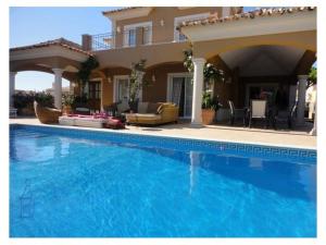 une grande piscine en face d'une maison dans l'établissement Villa Varandas Do Lago - 5 Bedroom villa - Stunning pool area - Table tennis, à Vale do Lobo