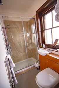uma casa de banho com um chuveiro, um WC e um lavatório. em The Station Guest House em Woodbridge