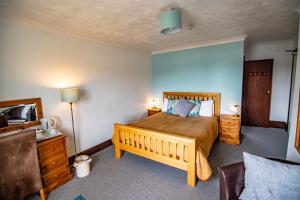 a bedroom with a large wooden bed and a couch at The Station Guest House in Woodbridge