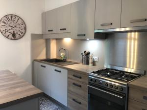 eine Küche mit einem Herd und einer Uhr an der Wand in der Unterkunft L'Appartement d'Hélène in Sarlat-la-Canéda + 9 Fotos