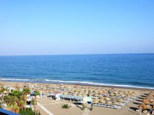 a beach with a lot of umbrellas and the ocean at playamar in Torremolinos