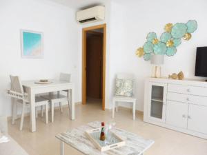 ein weißes Wohnzimmer mit einem Tisch und einem Schreibtisch in der Unterkunft Bleu Mare Apartment in Torremolinos
