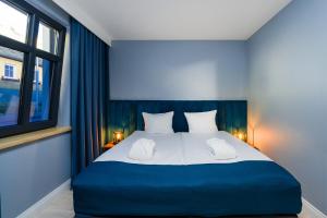 Un dormitorio con una cama azul y blanca y una ventana. en Kurort Kameralny, en Mikołajki