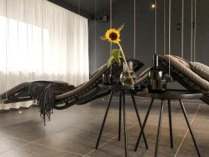 a bed with a table with a sunflower on it at ride & relax Aparthotel Schwarz in Eben im Pongau