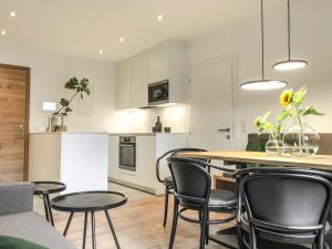 una cucina e un soggiorno con tavolo e sedie di ride & relax Aparthotel Schwarz a Eben im Pongau
