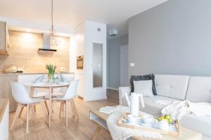 a living room with a white couch and a table at Kamienica Parkowa in Dąbki