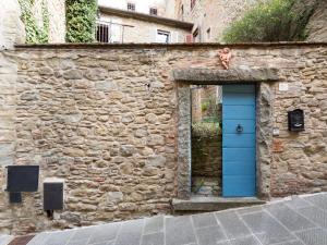 
a stone building with a blue door and windows at Casa Amorino- Together Tuscany in Cortona

