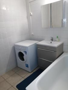 baño blanco con lavadora y lavamanos en Boulevard Paul Valéry en Montpellier