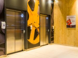 two elevators with a large pair of scissors on the wall at ibis Uberaba in Uberaba
