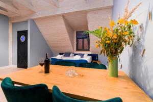 a dining room with a table with a vase of flowers at Kurort Kameralny in Mikołajki +54 photos