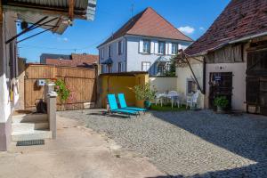 un patio con una silla azul y una casa en MA ROSE DES LUMIERES maison indépendante 6 personnes avec grande cour, en Griesheim-près-Molsheim
