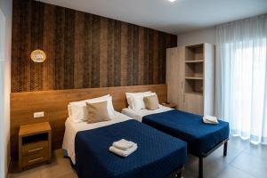 pokój hotelowy z 2 łóżkami z niebieską pościelą w obiekcie Gu Hotel w mieście Guidonia Montecelio
