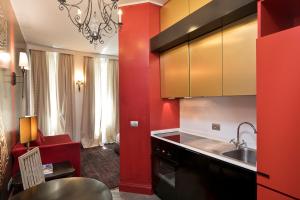 uma cozinha com paredes vermelhas, um lavatório e um balcão em Turin Tales Luxury Apartments em Turim