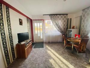 ein Wohnzimmer mit einem TV und einem Schreibtisch mit einem Tisch in der Unterkunft Amazing House Cazare in Sibiu