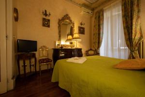 una camera con letto verde e specchio di Antica Dimora Isernia a Isernia