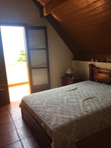 um quarto com uma cama e uma grande janela em Casa com linda vista para o mar para amantes da natureza em Ubatuba