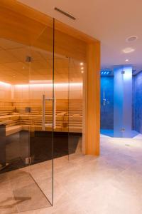 a glass wall in a bathroom with a shower at AMERON Davos Swiss Mountain Resort in Davos