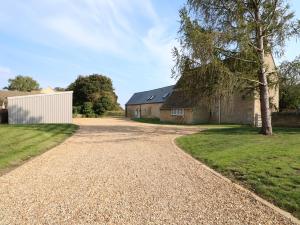 una entrada de grava frente a una casa en The Croft Farm en Peterborough