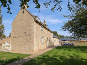 un antiguo edificio de piedra con un patio de césped en The Croft Farm en Peterborough