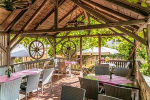 uma área de refeições exterior com mesas e cadeiras num pavilhão em Gasthaus & Weingut zum Stern em Sulzfeld am Main