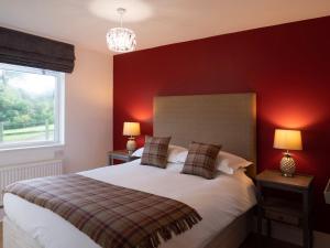 a bedroom with a large bed with red walls at The Garden House B&B in Bristol