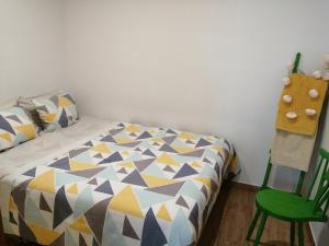 a bedroom with a bed and a green chair at Turismo Rural casa da céu in Amiães de Cima