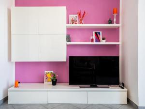 a living room with a tv and purple wall at The Best Rent - Modern two rooms apartment with balcony in Milan