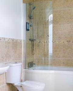 a bathroom with a shower and a toilet and a tub at The Garden House B&B in Bristol