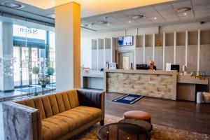 a lobby with a couch in front of a counter at Hotel Stayen in Sint-Truiden