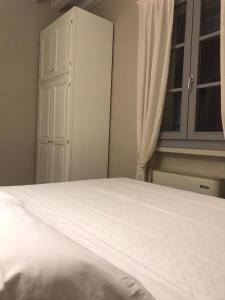 ein Schlafzimmer mit einem weißen Bett und einem Schrank in der Unterkunft Agriturismo Cascina Carai in Marone