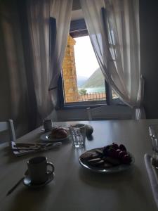 a table with two plates of food and a window at Agriturismo Cascina Carai in Marone