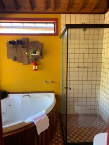 a bathroom with a tub and a glass shower at Canto da Colina Lumiar in Lumiar