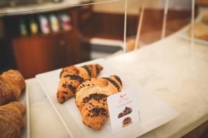 a bunch of pastries on a plate in a display case at Hotel Posta in Cecina