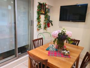 a dining room table with a vase of flowers on it at Amber Guest House in London