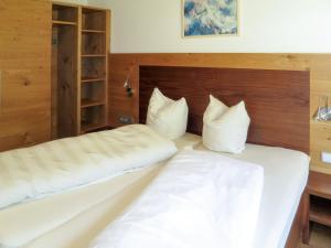 two beds in a hotel room with white pillows at Apartment Simon-2 by Interhome in Kappl