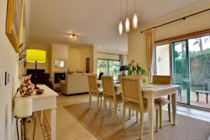 韋爾都勒博的住宿－Villa Vale Do Lobo 176 - 4 Bedroom villa - Great pool area - WiFi and Air conditioning，用餐室以及带桌椅的起居室。