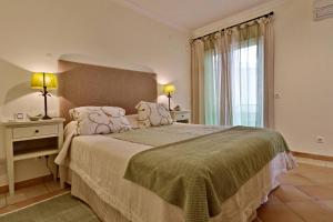 韋爾都勒博的住宿－Villa Vale Do Lobo 176 - 4 Bedroom villa - Great pool area - WiFi and Air conditioning，一间卧室设有一张大床和一个窗户。