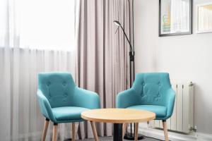 two blue chairs and a table in a room at Holiday Inn Hemel Hempstead M1, Jct. 8, an IHG Hotel in Hemel Hempstead
