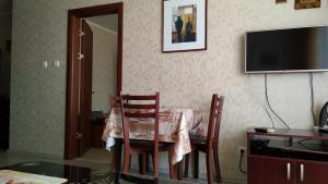 a dining room table with chairs and a television at Nesebar Vigo Panorama Private Studios in Nesebar