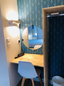 Habitación con espejo y escritorio con silla. en Fasthôtel Clermont-Ferrand Gerzat, en Gerzat