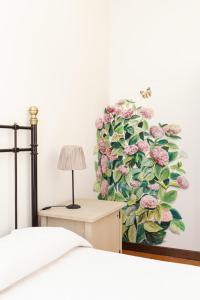 un dormitorio con una pintura de flores en la pared en B&B Murolungo, en San Lazzaro di Savena