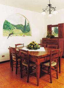 comedor con mesa de madera y sillas en B&B Murolungo, en San Lazzaro di Savena