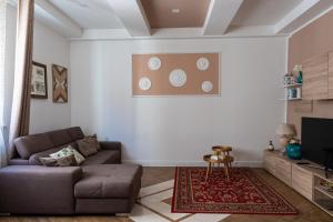 a living room with a couch and a tv at Gold Maison in Ferrara