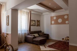 uma sala de estar com um sofá e uma mesa em Gold Maison em Ferrara