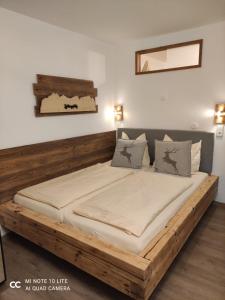 um quarto com uma cama grande e uma estrutura em madeira em Berghof Apartment Bergwiese Top 31 em Ellmau
