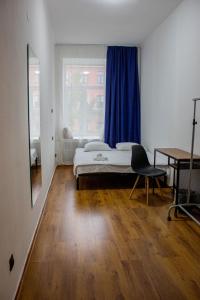 ein Schlafzimmer mit einem Bett und einem blauen Vorhang in der Unterkunft Simple Seasons Rooms - Самозаселение in Sankt Petersburg